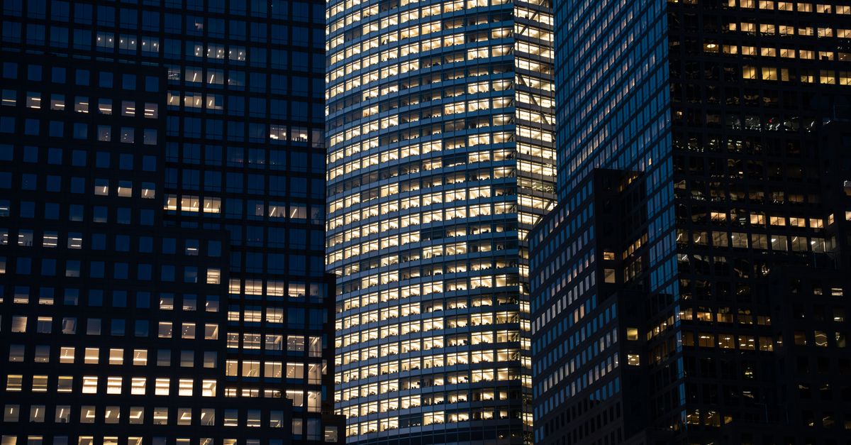Skyscrapers with glowing windows create a vibrant nighttime cityscape.